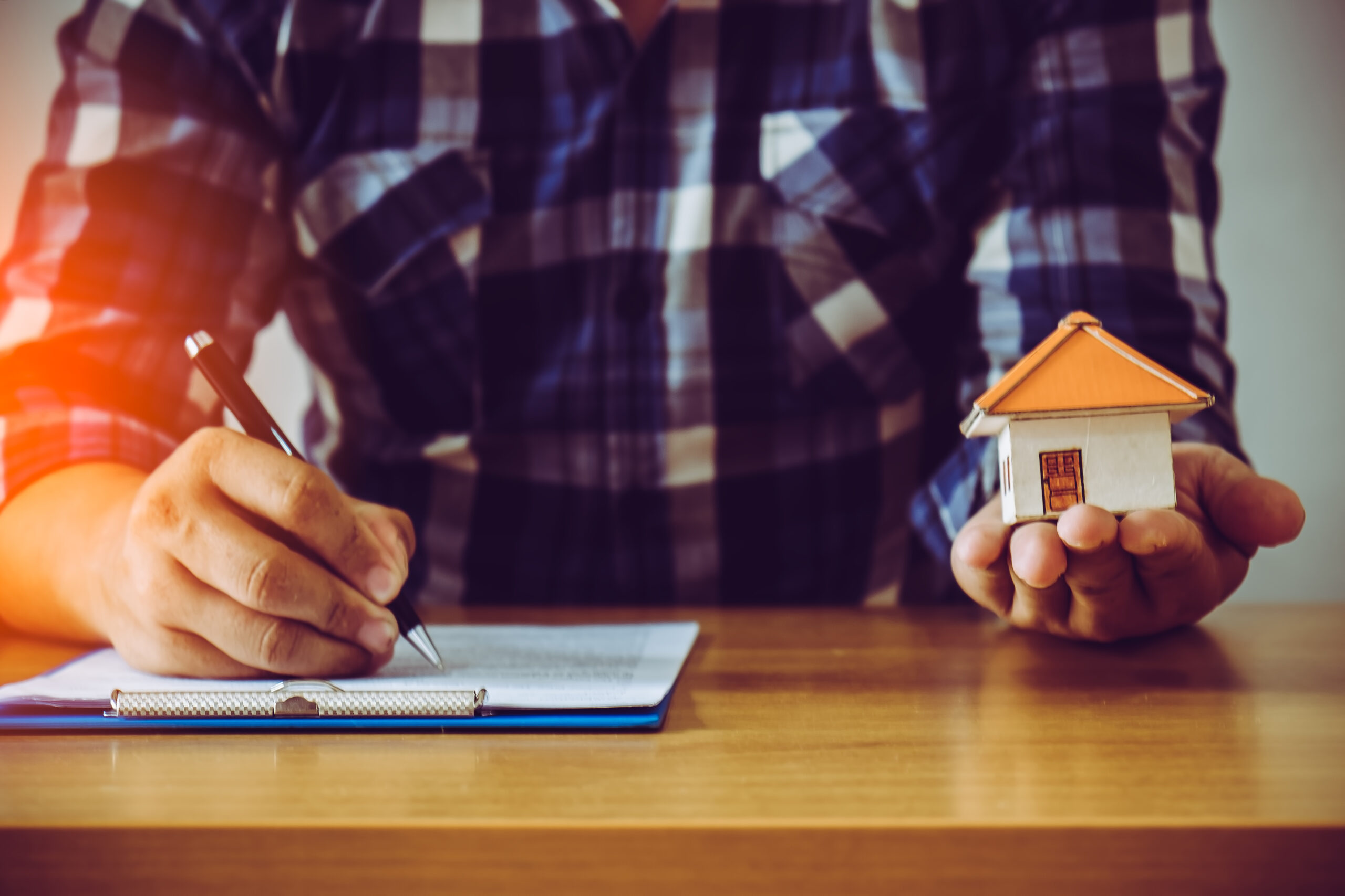 Businessman holding paper home model. Loan concept Rental Real Estate Appraisal in Tampa Bay