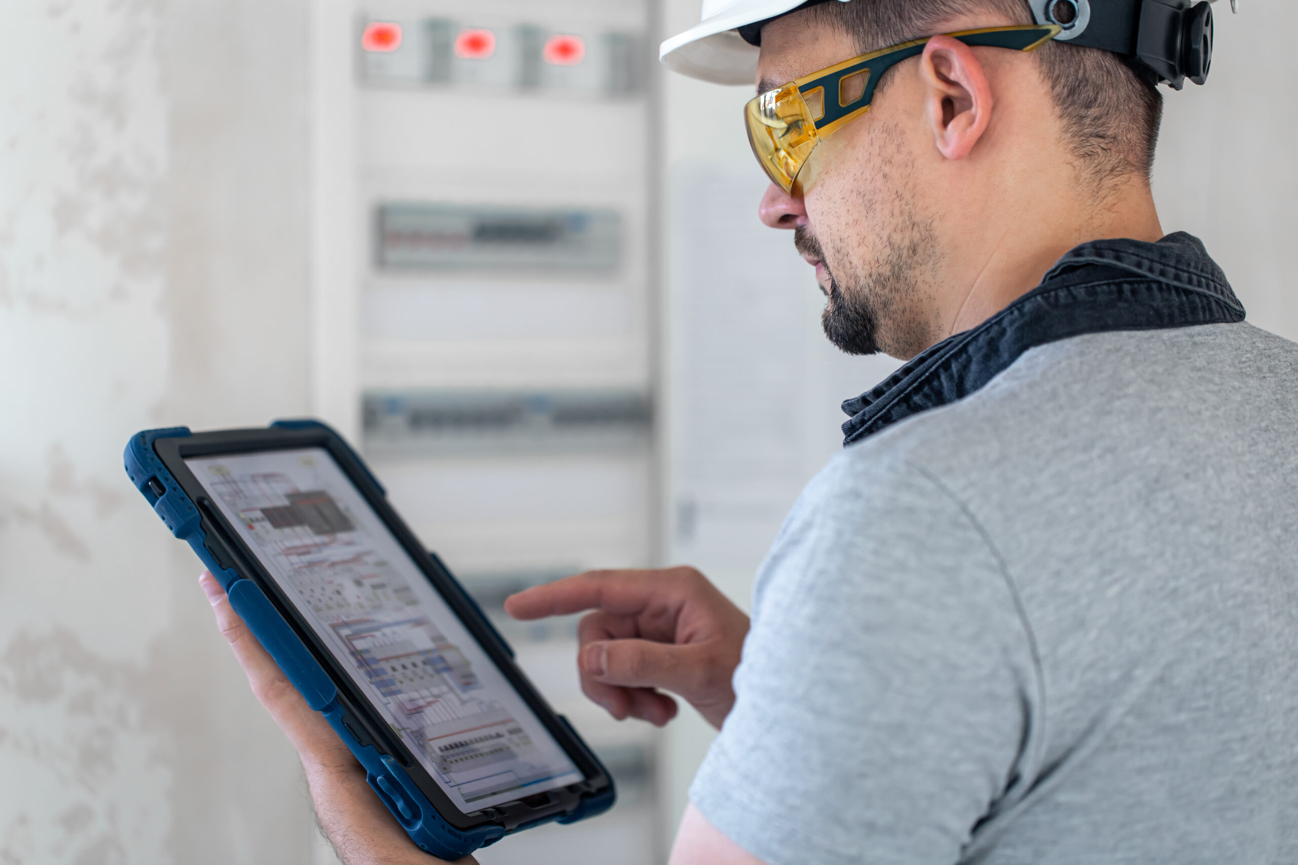 Electrical technician looking focused while working in a switchboard with fuses. rental real estate appraisal in Tampa Bay, Fl